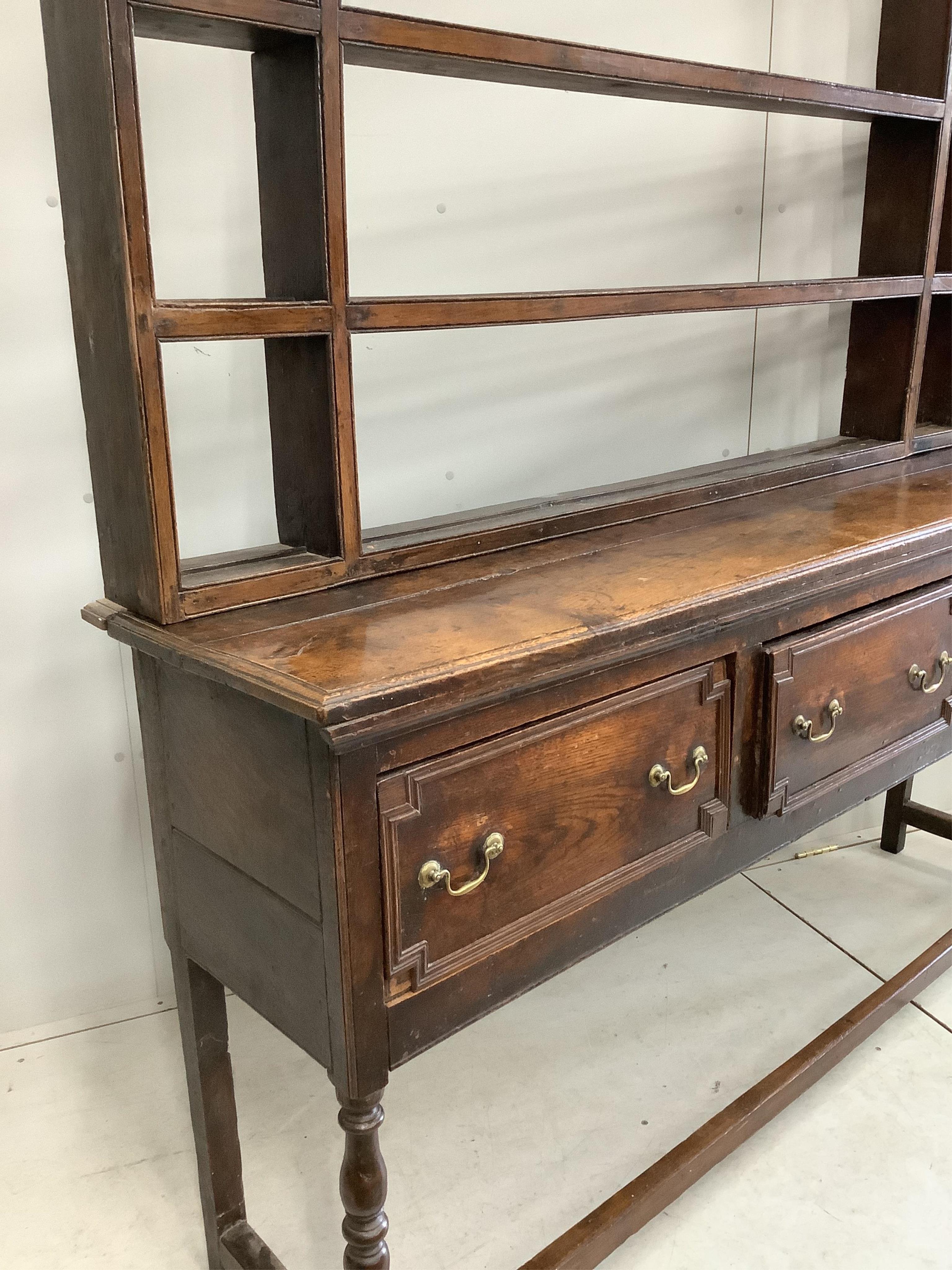 An 18th century oak dresser with open rack, width 176cm, depth 46cm, height 199cm. Condition - fair